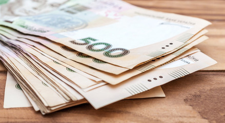 Heap of 500 hryvnia bills on wooden table. Close up.