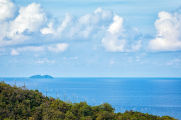 wind turbine generating electricity on mountain near sea.