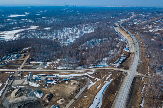 Aerial drone top view photo of track road in the industrial area with construction sites in the springtime with unmelted ice