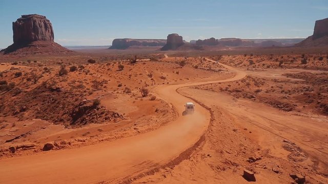 Road trip through the stunning desert scenery. Traveling along huge sandy canyon. Monument Valley, Navajo Tribal Park, AZ, USA
