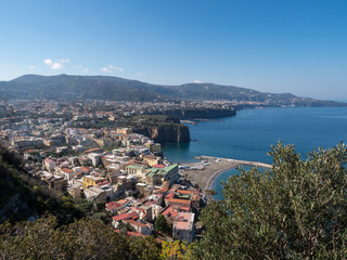 Fototapeta na wymiar Amazing aerial view of coastline Sorrento city and Gulf of Naples - popular tourist destination in Italy. Sunny summer day with blue sky, clear sea and green mountains. Italy, april 2019