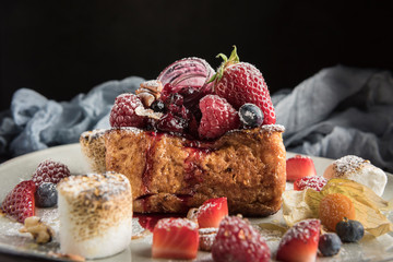 Gourmet brioche french toast with berries and marshmallows. Dark background. Horizontal. Copyspace.