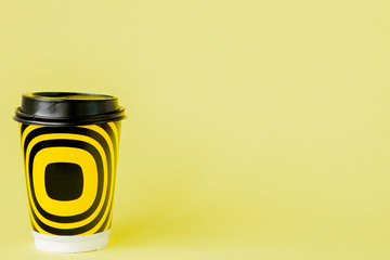 Take-out coffee in thermo cup on a yellow background, Copy space