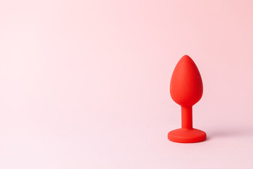 Red butt plug on pink background. Sex toys for ass. Copy space for text.