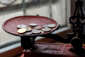 coins on a red metal plate Roberval balance