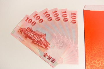 Red envelope packet with Taiwan money on white background for Chinese New Year. Translation: Good luck in the year.