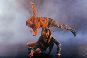 The beautiful female dancer is laying on the floor while her male partner performs an exotics unique modern art moves over her.