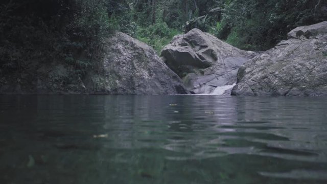 SLOW MOTION: low over the water looking towards Mango Waterfall in Adjuntas, Puerto Rico.