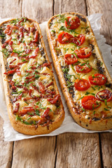 Hot sandwiches with bacon, mushrooms, tomatoes and cheese close-up on parchment. vertical