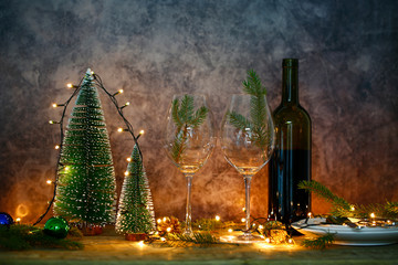 Red wine on table with Christmas tree. Christmas table and tree.