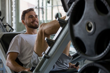 sport man doing exercises with leg press machine in fitness gym . workout . training