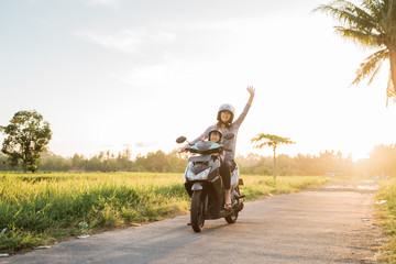 mom and her child enjoy riding motorcycle scooter in country ride road © Odua Images