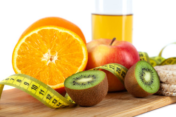 Apple, orange, kiwi with measure tape on white background