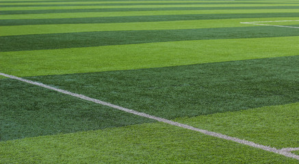 green grass football field surface textured wallpaper sport pattern with white marking and cutting...