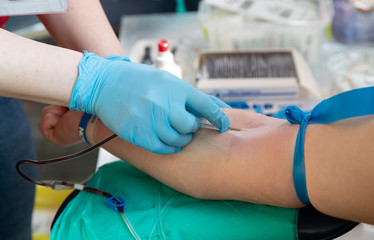 Blood donor at donation. Nurse receiving blood from blood donor