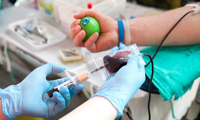 Blood donor at donation. Nurse receiving blood from blood donor