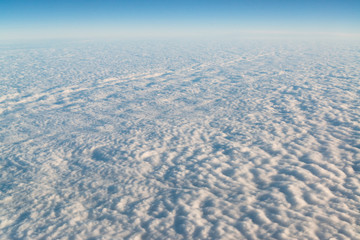 View from airplane on white thick clouds sky