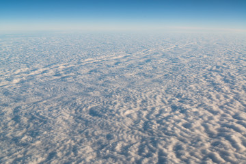 View from airplane on white thick clouds sky