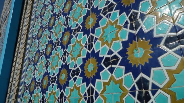 A panning, close up shot of a wall made out of vivid mosaic tiles.
