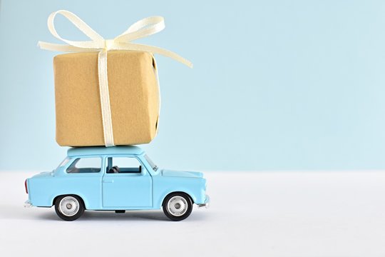Happy fathers day concept, blue retro toy car delivering gift box, space for text.