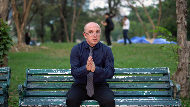 Nervous Late 20s Man Waiting For Date on Park Bench 