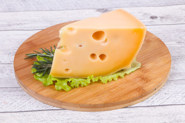 Maasdam cheese  in the board served salad leaves