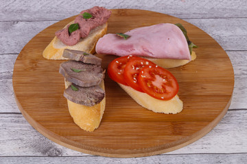 Bruschetta with tomato, ham and tongue