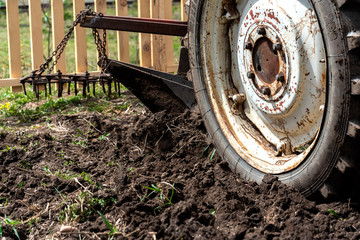 old small tractor harrow field in spring, Caucasus. Karachay-Cherkessia Russia