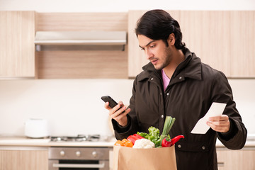 Young handsome man with vegetables in the kitchen 