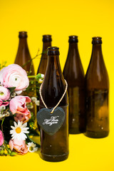 Bierflaschen mit Herz, von Herzen, Blumen, gelber Hintergrund