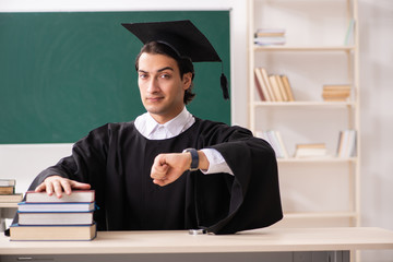 Graduate student in front of green board 