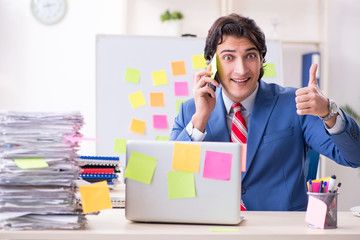 Young male handsome employee in conflicting priorities concept 