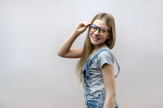 Portrait of a smiling beautiful young girl with glasses. Smart child. Nerdy