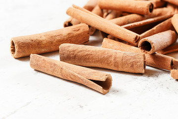 Pile of organic cinnamon bark sticks on white board