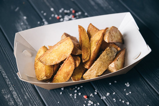 Baked potatoes.Snack in paper eco-friendly boxes. Takeout food in a paper box. Fast food on the street. To go Snacks.