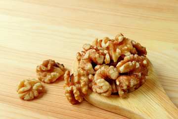 Uncooked Walnut Kernels Scattered from the Ladle on Wooden Table