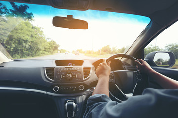 Man driver hands holding the car steering panel