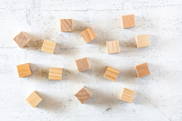 Blank wooden cubes scattered on white stone board, flat lay photo
