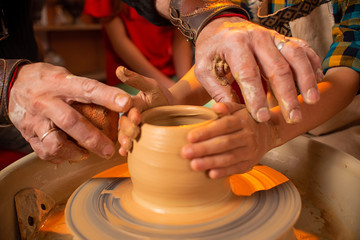 Children's hands work with clay on a special machine. Products from clay. Pottery