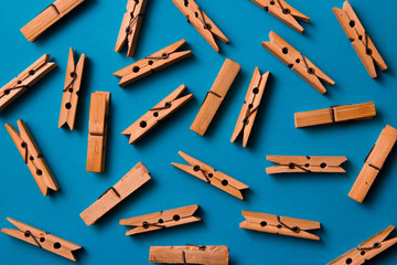 wooden clothespins on a blue background. Flat lay, top view