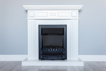  White wooden decorative electric fireplace. Interior photo on gray background.