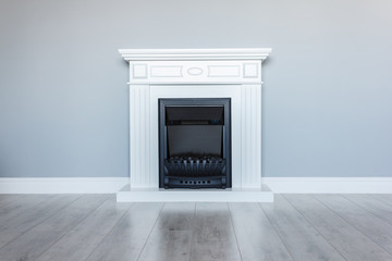  White wooden decorative electric fireplace. Interior photo on gray background.
