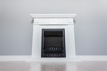  White wooden decorative electric fireplace. Interior photo on gray background.