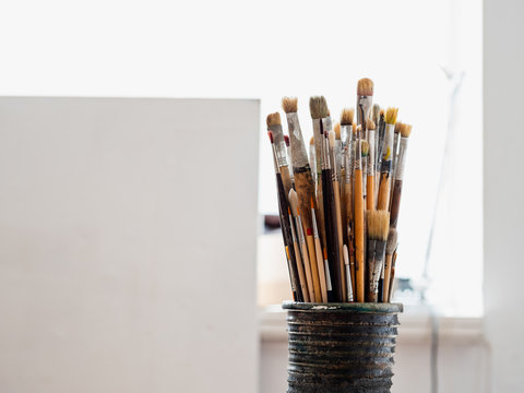 Artist's studio - jar of paint brushes in a workshop with natural light
