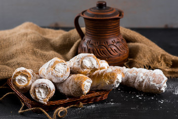 Sweet tasty pastry filling with cream on the black background