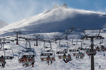 Naklejka premium Chairlifts for skiers with snow flurries high up in the Sierra Nevada