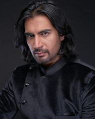 Portrait of Indian man with long black hair in studio