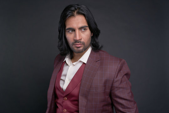 Portrait of Indian man with long black hair in studio