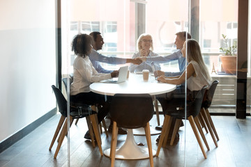 Happy diverse businessmen handshake at group meeting negotiation in boardroom