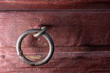 Welded metal link in red wooden wall